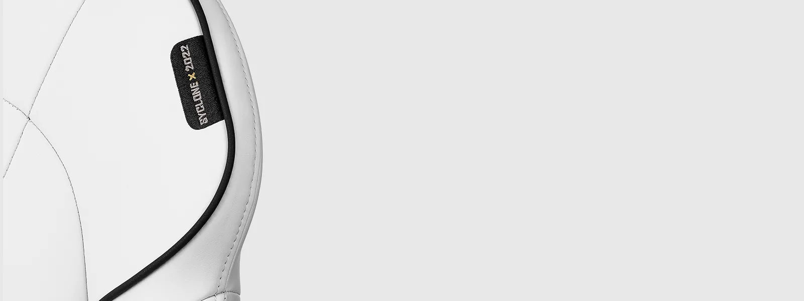 Detail of the white SYCLONE PRO gaming chair's side stitching and label.