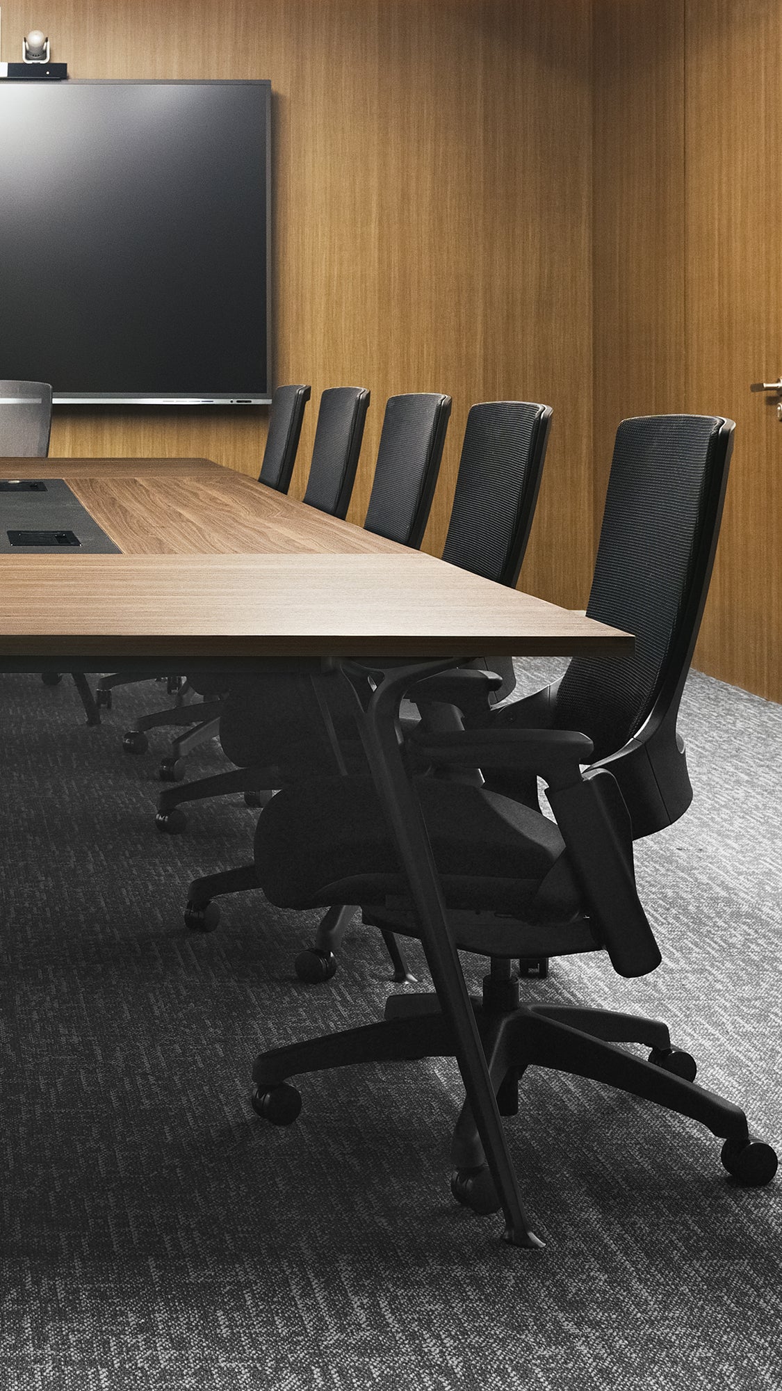 Elegant boardroom with Flujo office chairs around a large wooden table, illustrating a professional and stylish meeting environment.
