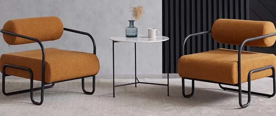 Elysia round marble coffee table with minimalist black metal frame, styled in a modern living room beside a yellow fabric sofa