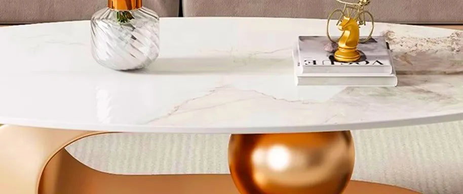 Flujo Elara modern luxury coffee table with golden base and white marble top, placed in a stylish living room setting with a beige sofa and decorative cushions