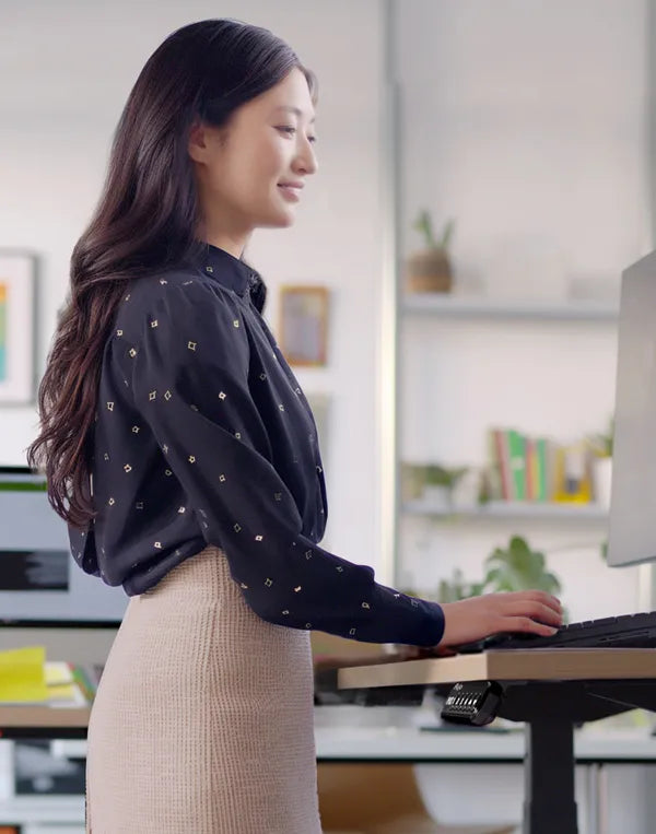 Professional woman using a standing desk in a vibrant office environment